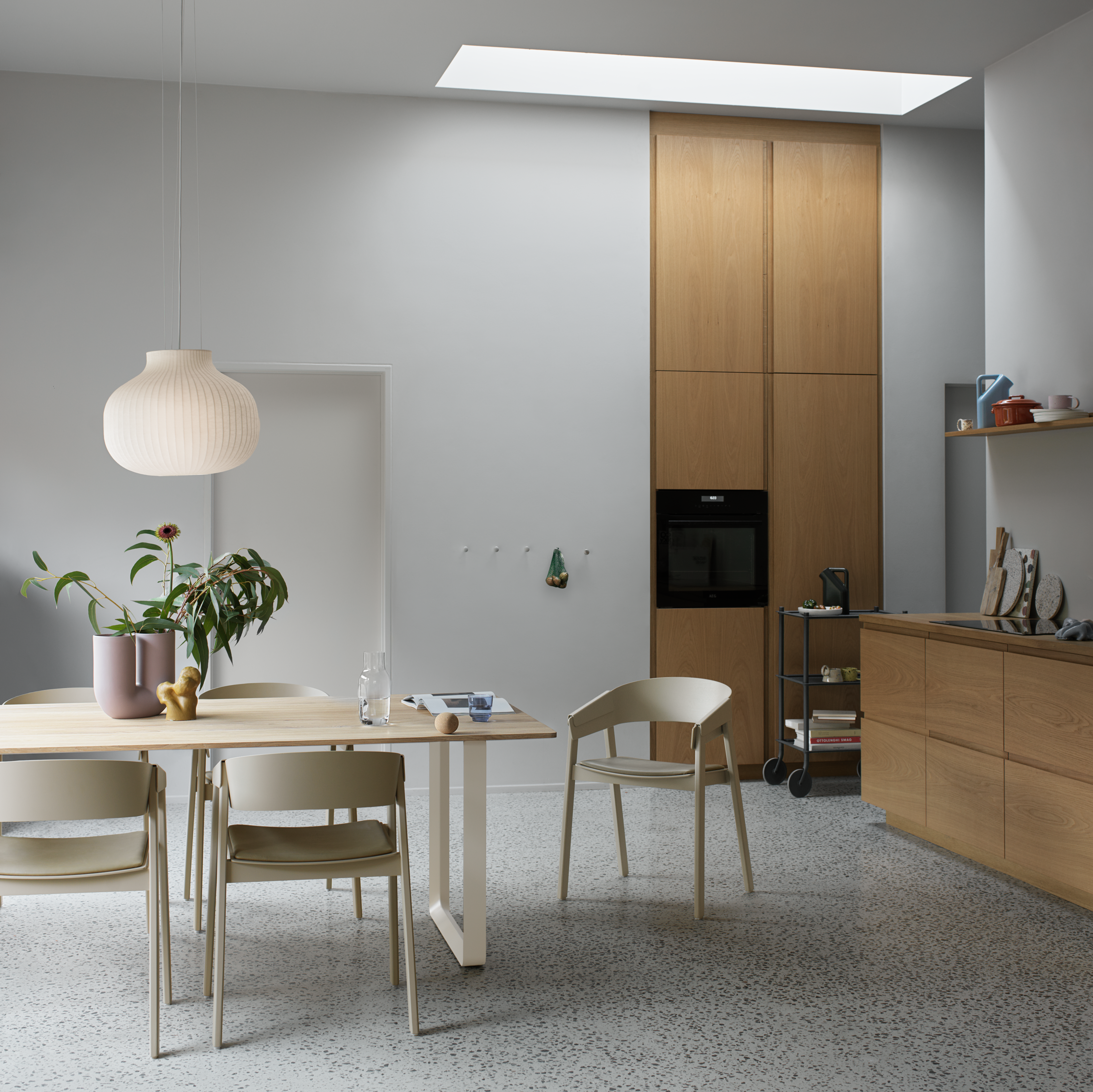 Cover Armchair in Dark Beige/Refine Leather Stone - 70/70 Table in Sand/Solid Oak 255x108 cm - Strand Pendant Ø45 - Kink Vase in Dusty Lilac - Flow Trolley - Dots in Aluminum