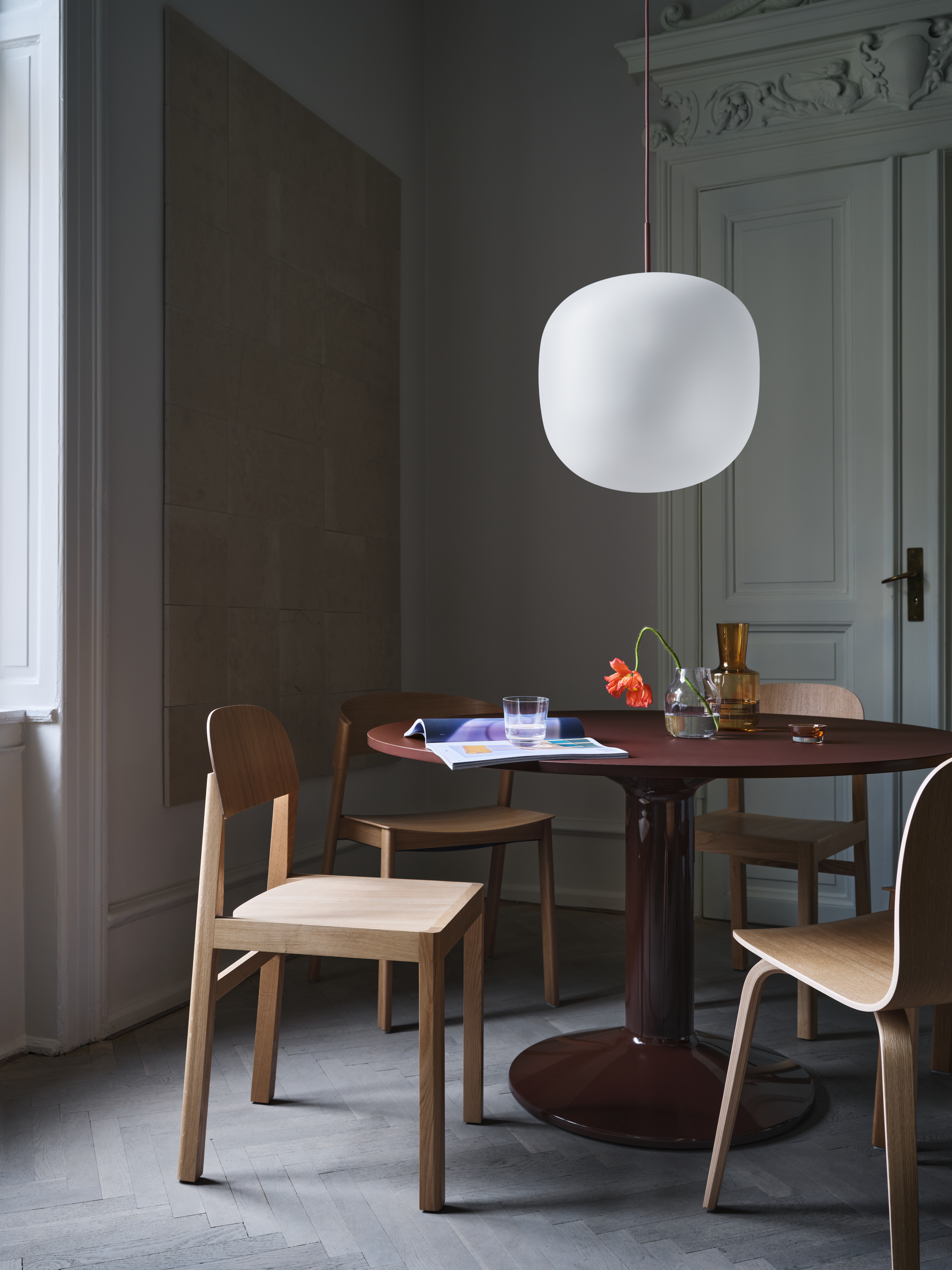 Midst Table Ø120 cm in Dark Red - Rime Pendant Ø45 cm in Deep Red - Workshop Chair in Oak - Cover Side Chair in Oak - Visu Chair in Oak - Silent Vase Ø20 in Clear & Burnt Orange, Ø11 cm in Clear - Raise Glass in Dark Blue