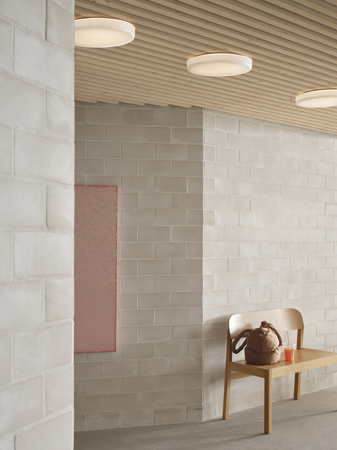 A round wall and ceiling lamp hanging above a workshop bench made of oak, creating a functional yet stylish setup.