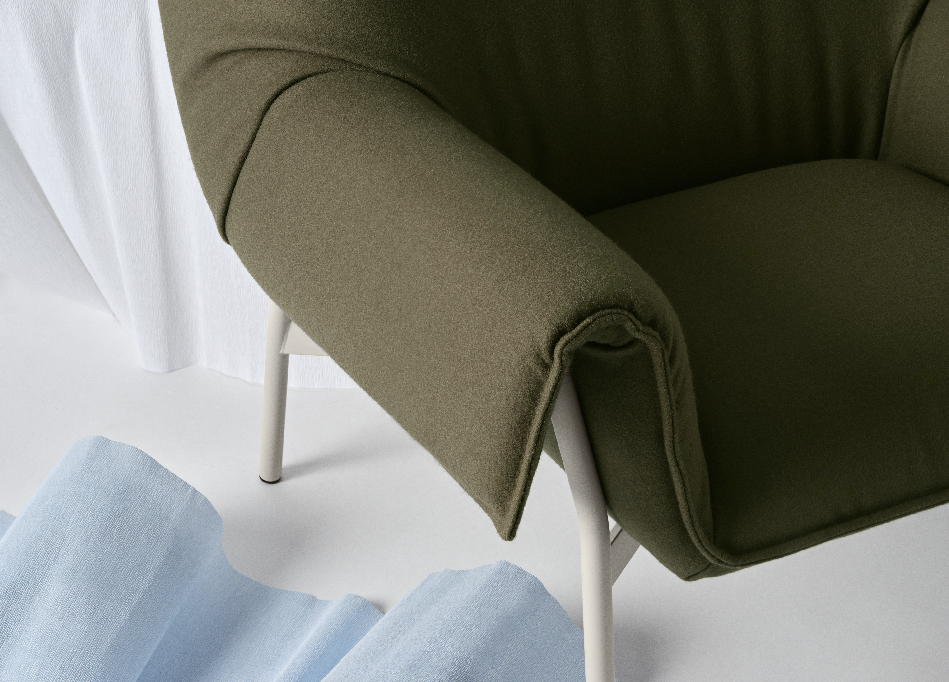 Close-up of Muuto Wrap Chair showcasing its soft upholstery and curved form.
