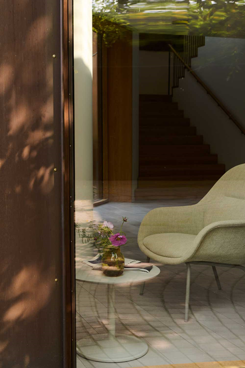 A large glass window. Natural light filters through, with reflections of trees visible on the glass pane.

